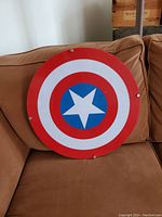 Front view of Captain America shield wall hanging showing the red, white, and blue design with central star.