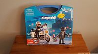 Front view of PLAYMOBIL Cops n Robbers set box showing police officer on motorcycle and robber figure.