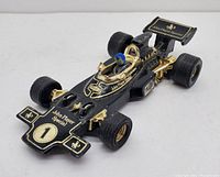 Front angled view of vintage CORGI Toys John Player Special F1 car model showing detailed black and gold paint with blue helmet driver figure.