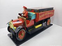 Side and angled view of the full vintage tin Fiat coffee delivery truck with driver figure mounted on black base.