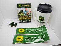 Overview photo of the complete lot showing the PC game, mug, tractor toy, and two stickers.