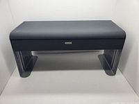 Front view of vintage Rolodex mini metal monitor shelf with drawer, showing dark textured surface and curved legs.