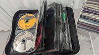 Photo of black CD binder open showing numerous CDs in plastic sleeves