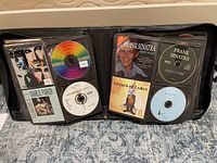 Photo of open binder with CDs visible including Charlie Parker, Frank Sinatra, Barenaked Ladies among others
