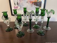 Group photo of all eight candlesticks arranged on a table showing variety in style and color.