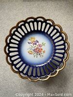 Top view of porcelain dish showing openwork scalloped rim, cobalt blue shading, and central floral painting.