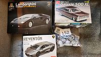 Three model kit boxes shown including Lamborghini Countach, Lamborghini Reventón, and 1965 Ford Galaxie 500 XL, with unassembled parts visible inside one box.