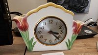 Front view of ceramic clock planter showing tulip motif and clock face