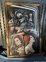 Photo of the framed black and white stylized portrait artwork showing five women with tattoos and face paint.