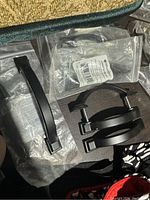 Seven black cabinet pulls, five smaller curved and two larger angular pulls, with packaging visible.