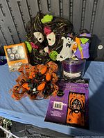 Photo of Halloween decorations including witch masks, pumpkin string lights, finger lights, LED candle and Trick or Treat decoration bag.