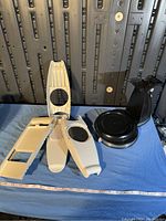 Multiple white mandoline slicers and black plastic round stand on blue cloth, side angle