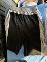 Black and gray boys shorts laid flat with elastic waistband and side panels