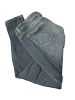 Folded blue denim jeans shown from backside with clear view of pockets and stitching.