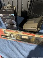 Photo of Polaroid camera, Amazon Alexa wireless speaker box, and packaged window shades on a blue cloth.