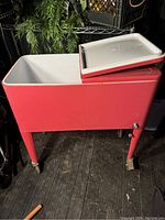 Front angled view of large red cooler showing white lid open and cooler interior.