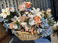 Close-up photo showing the silk flower arrangement's detail, color, and basket weave.