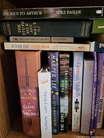 Books stacked on a shelf showing titles and authors including Game of Thrones and The Catcher in the Rye.
