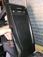 Front view of Casecom desktop tower case showing mesh front and optical drive bays with one optical drive.