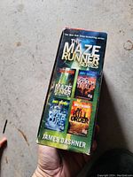 Photo of the boxed set showing cover art with book titles and author James Dashner.