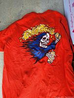 Back side of red Vans T-shirt showing large colorful skeleton graphic with 'Cold Ones' text