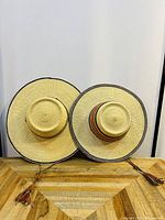 Two Bolga farmers sun hats positioned side by side showing top view with wide brim and crown details