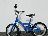 Side view of small blue kid's bike with black and orange seat, knobby tires, and padded handlebar crossbar with '16'.