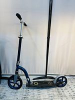 Side view of the blue and black Glober big wheel scooter set against a white backdrop.