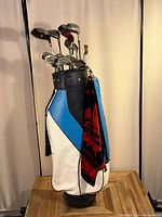 Golf bag with clubs from a side angle showing full set and attached towel.