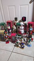 Full display of 19 nutcrackers of varying sizes and styles, some in boxes and others standing upright.