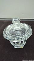 Clear fine crystal sugar bowl with attached lid on top, showing faceted edges and hexagonal knob handle.