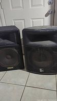 Yamaha S115V and Peavey PR15 speakers side by side showing wear