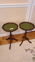 Pair of vintage wooden side tables with green felt octagonal tops, tripod base, standing on carpeted floor.