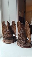 Front angled view showing detailed eagle carving and round base of both bookends.