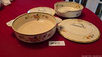 Set of three round Johnson Bros. serving bowls with lids; floral pattern and gold trim visible, wide handles on sides.