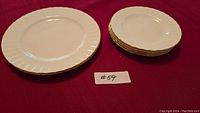 Two stacks of plates on red cloth, larger stack with four smaller plates, smaller stack with two larger plates
