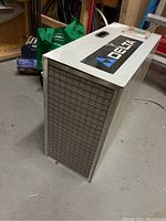 Full view of the metal Delta air cleaner unit with large front filter grid and visible dust.