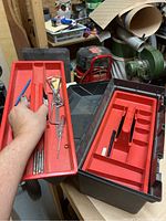 Photo of red plastic trays removed from tool box showing compartments and small tools inside
