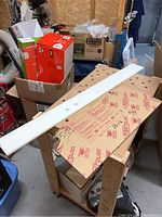 Image showing white ice shooting pad sheet on a wooden workbench with surrounding workshop items.
