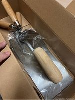 Two Lee Valley trowels with wooden handles in original plastic sealed inside a cardboard box