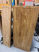 Two hardwood wood tops standing upright, showing rectangular shape and wood grain finish.