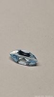 Photo of natural marquis cut sky blue topaz gemstone showing faceted surfaces and clarity.