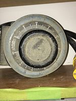 Front view of large rotary knob with voltage scale and Powerstat logo, showing some dust and wear.