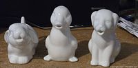 Front view showing the dog, duck, and bunny shaped ceramic pourers lined up on a surface.