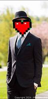 Man wearing the black suit with a blue tie and pocket square outdoors