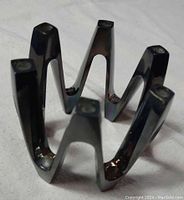 Metal Dansk Crown candleholder with 12 candle holders arranged in a zig-zag crown shape.