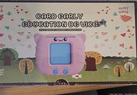 Photo of the front of the sealed boxed device showing the pink education device image and packaging design.