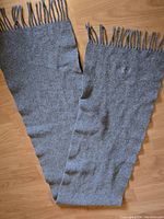 Grey scarf laid flat showing full length and fringed ends