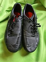 Top view of both black Nike Phantom soccer shoes showing the textured upper and Nike swoosh logos on the toes.