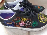 Left side of Vans sneakers showing floral embroidery and positive words